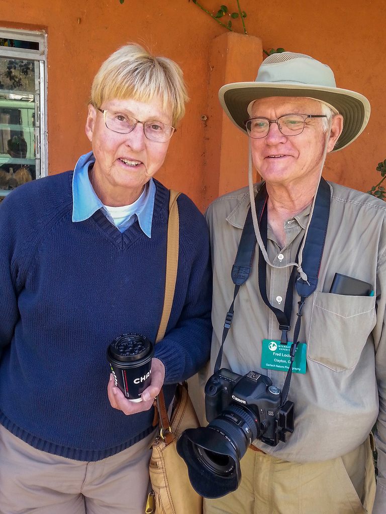 A man and a woman carrying cameras